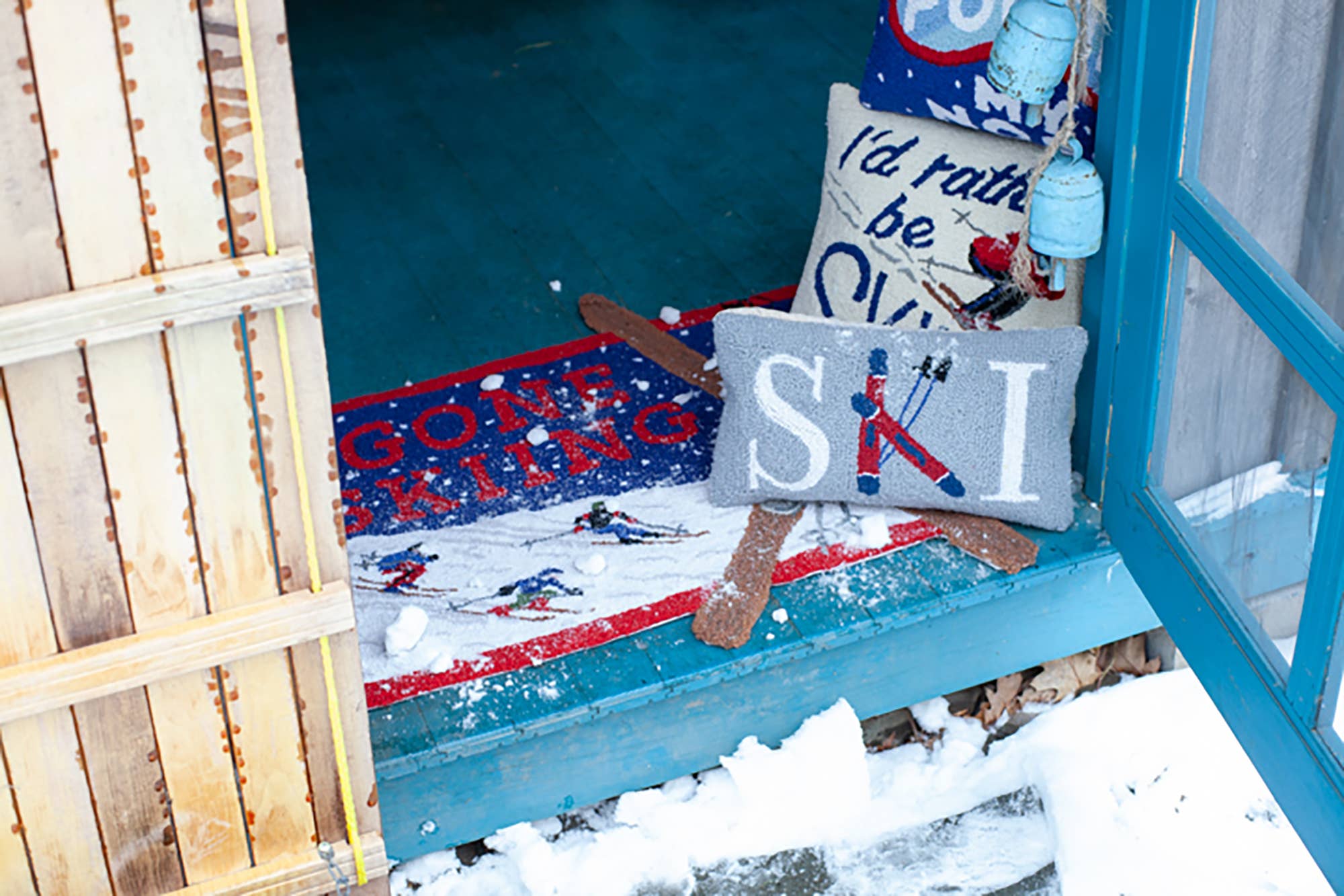 Decorative pillows and rug on a porch with winter-themed text